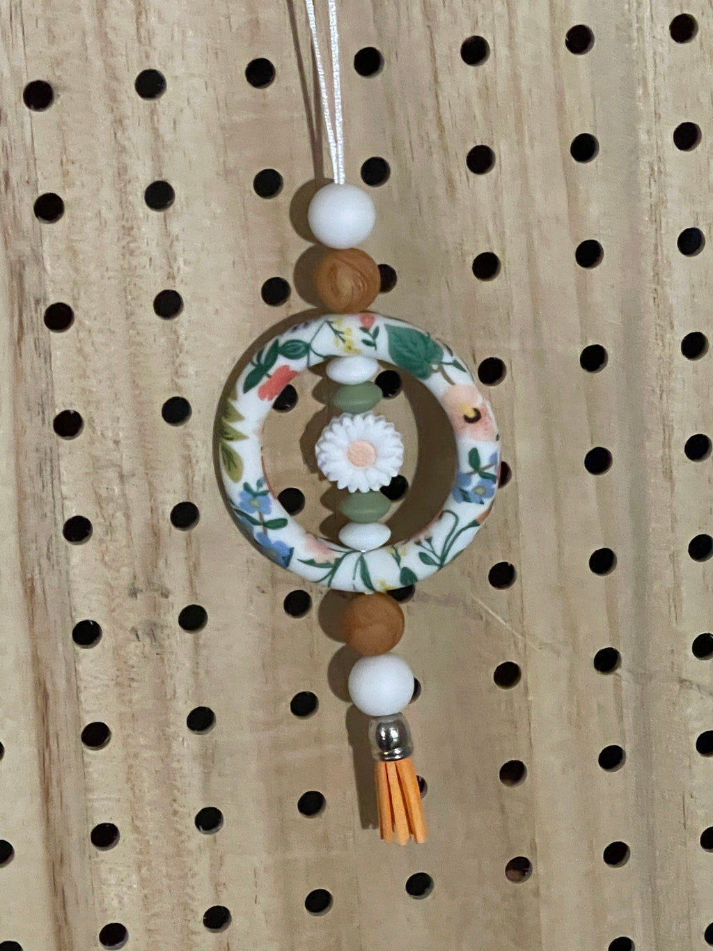 White floral, orange and brown car charm 