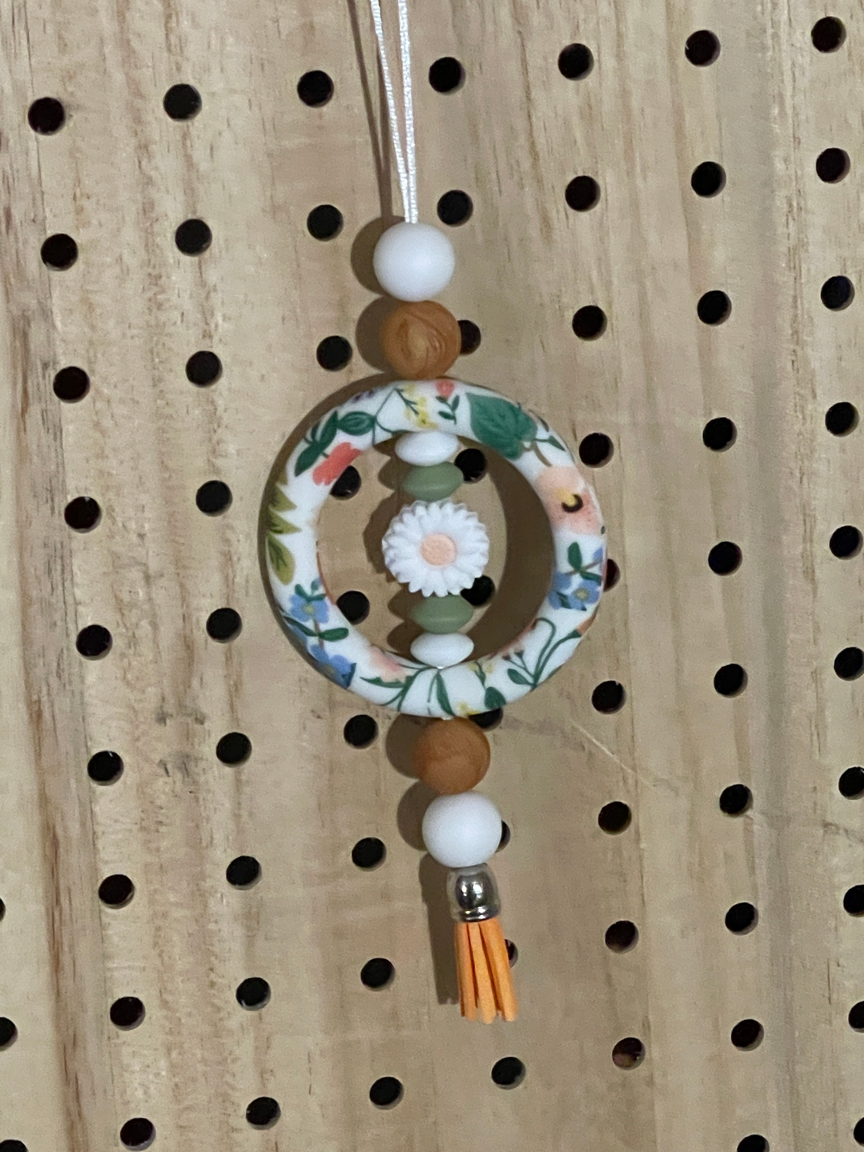 White floral, orange and brown car charm 